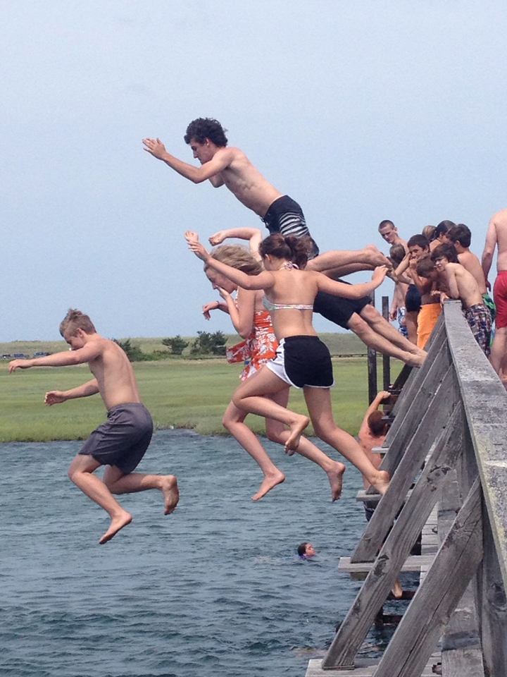 kids jumping off sandwich boardwalk bridge
