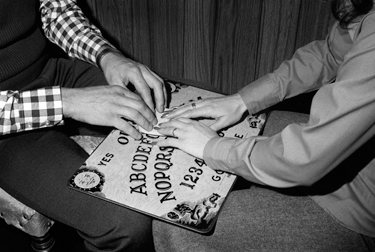 Using Ouija Board --- Image by © Bettmann/CORBIS